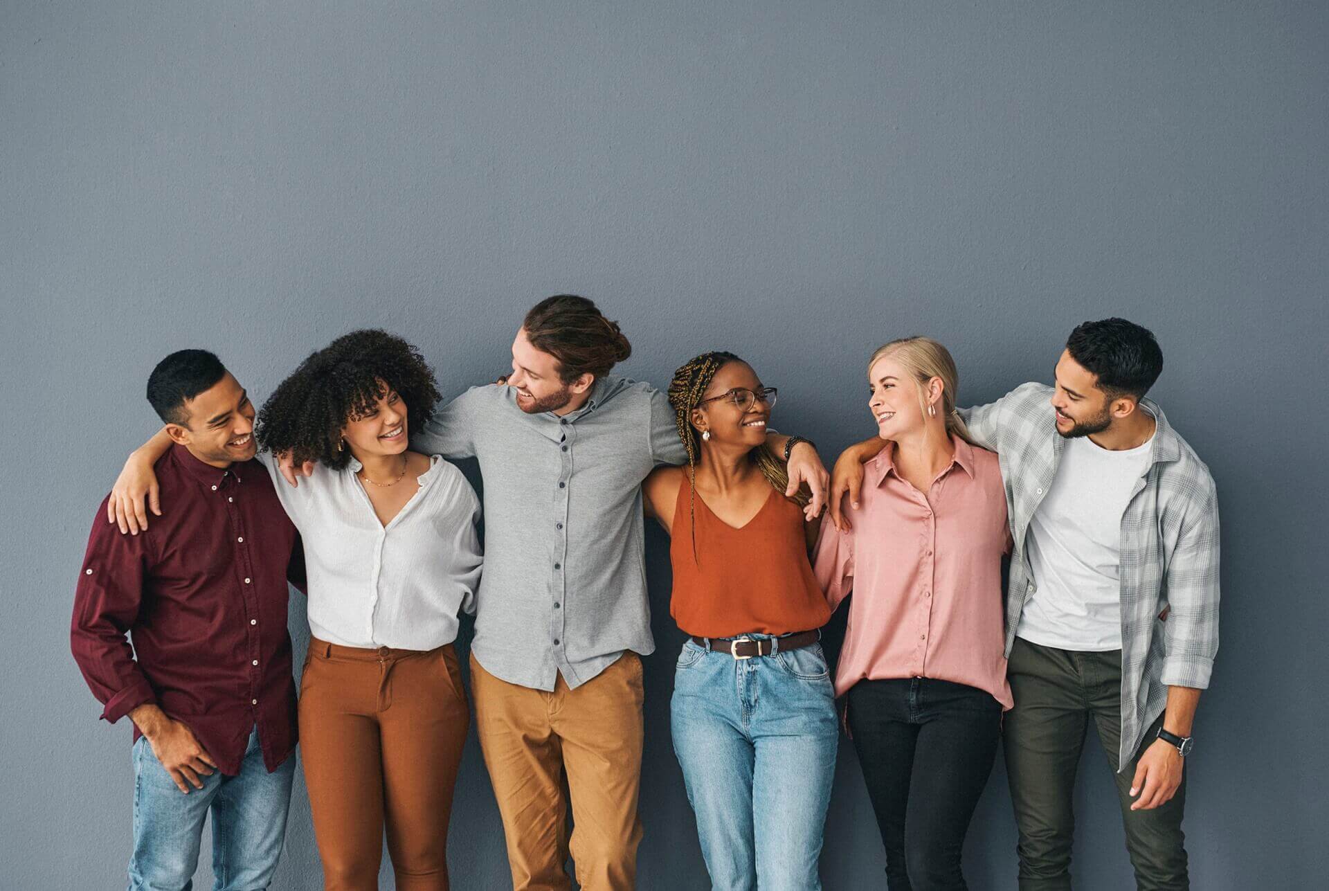 cropped-shot-of-a-young-and-diverse-group-of-businesspeople-standing-together-against-a-grey-background